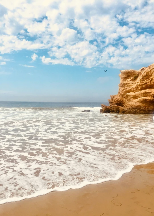 a person standing on a beach with the ocean in front