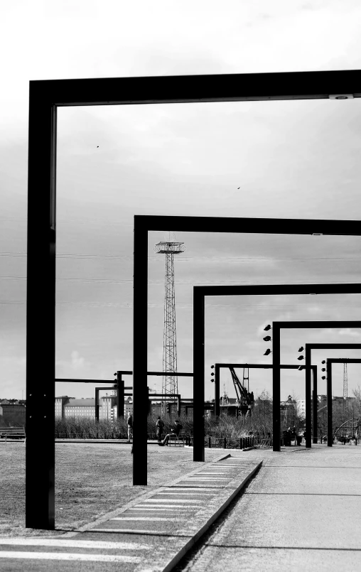 a row of metal structure next to a dirt road