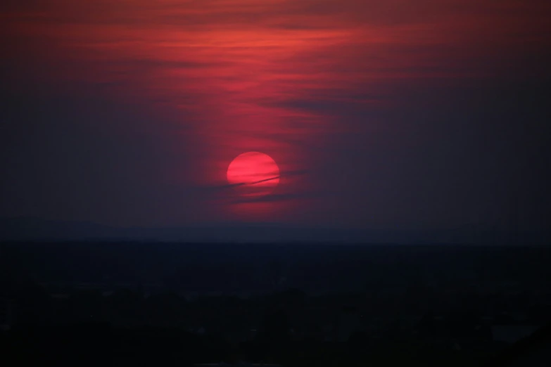 the sun setting on a dark city during a very nice day