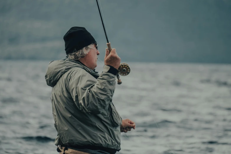 an older man is holding a fishing rod and hook