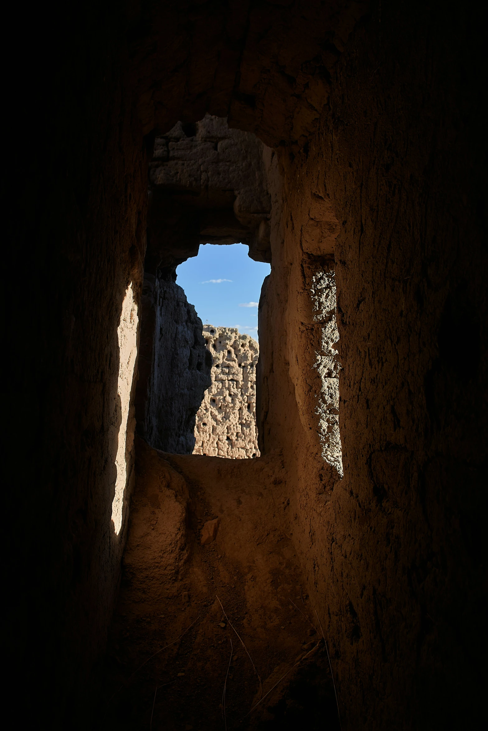 a window in a wall that appears to be made of mud