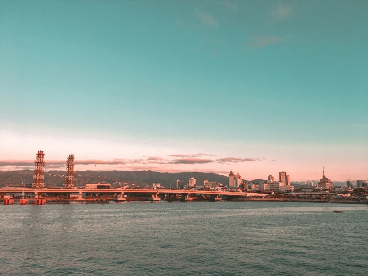 the view of a city and some hills on water