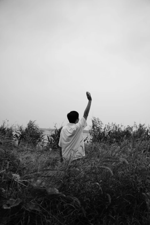 a man sitting in the grass and flying a kite