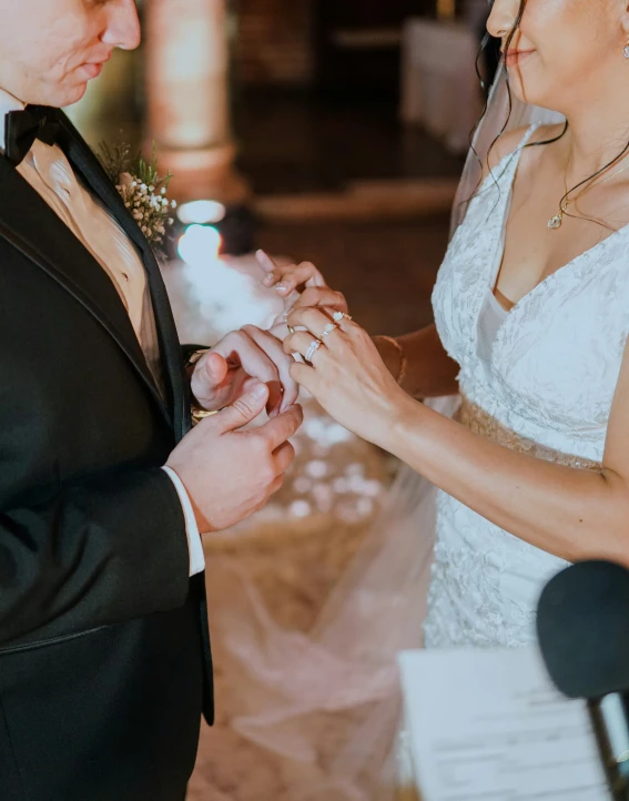 the bride and groom are putting on their rings