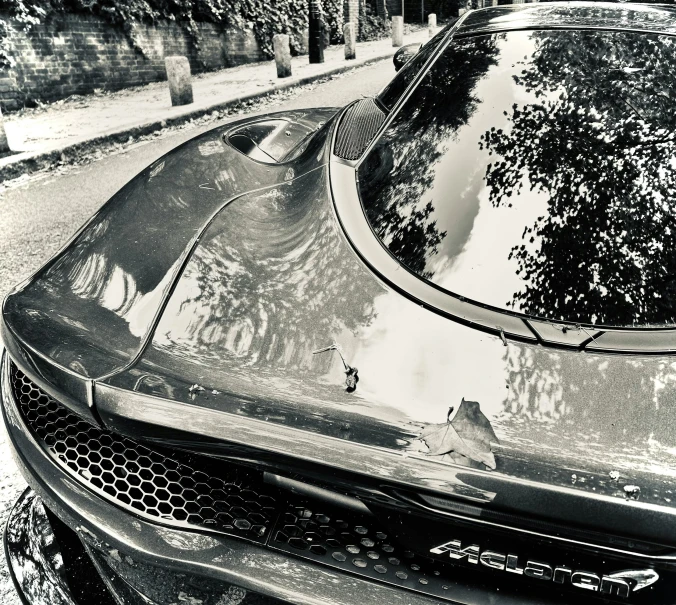 a sports car in black and white parked along the side of the road