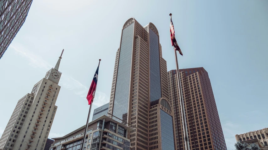 a row of buildings with flags flying in the sky