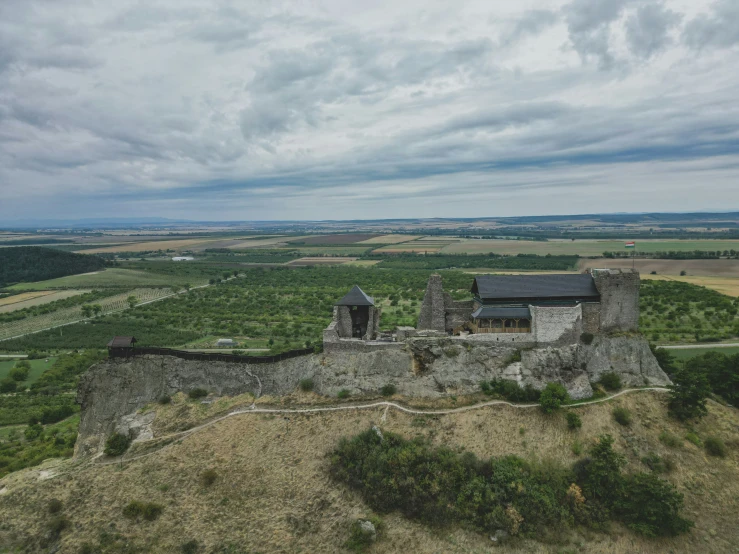 a very old castle sitting on top of a grass covered hillside