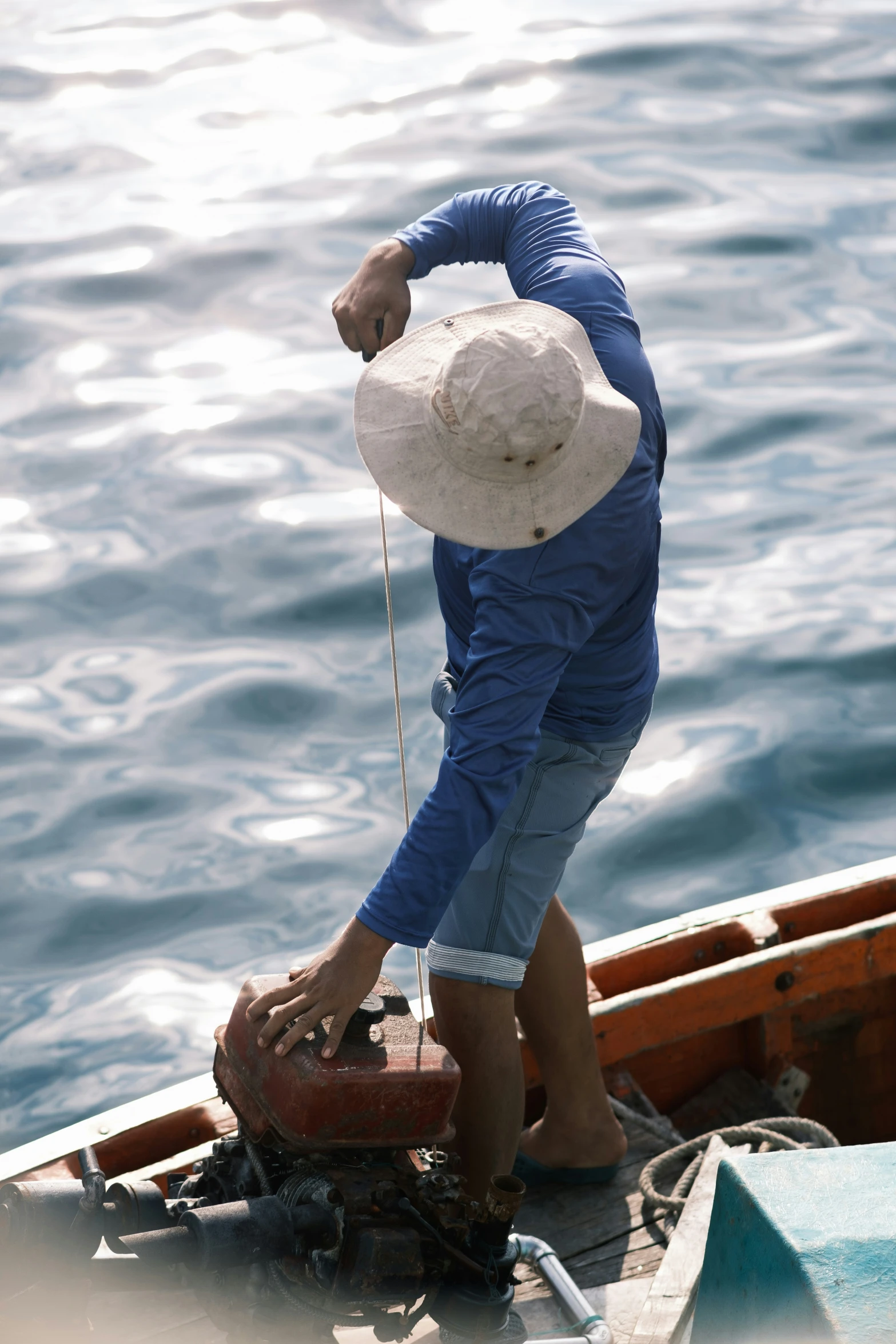 a man with hat pulling a boat from the water