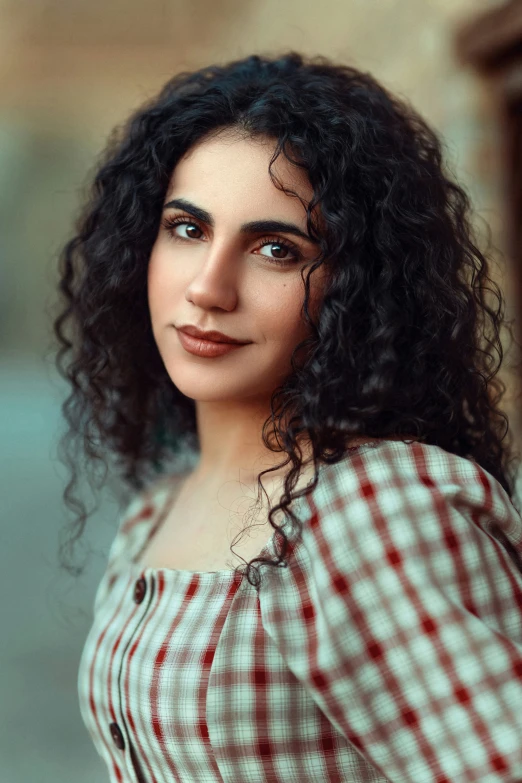 a woman with curly hair in a plaid shirt and red and white on up