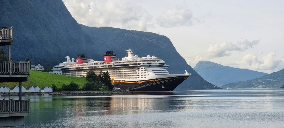 cruise ships are seen on the water in a large mountain area