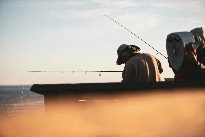 two men sitting on a boat while fishing