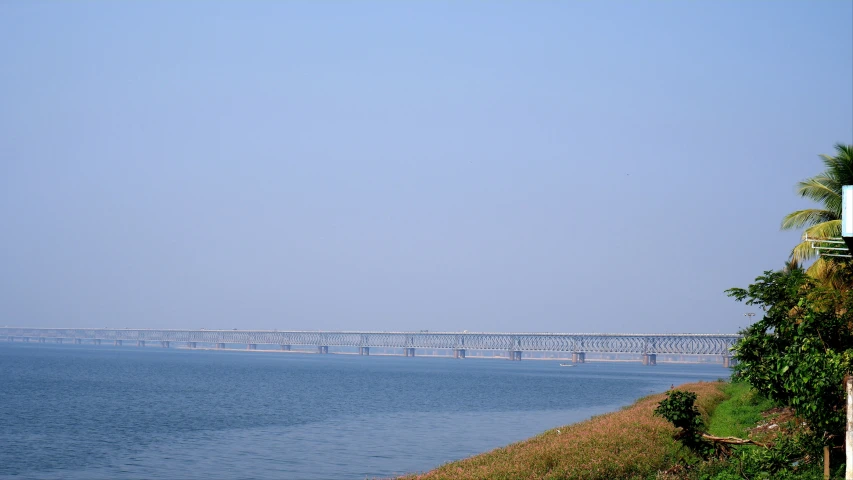 a large bridge over a blue ocean on top of a hill