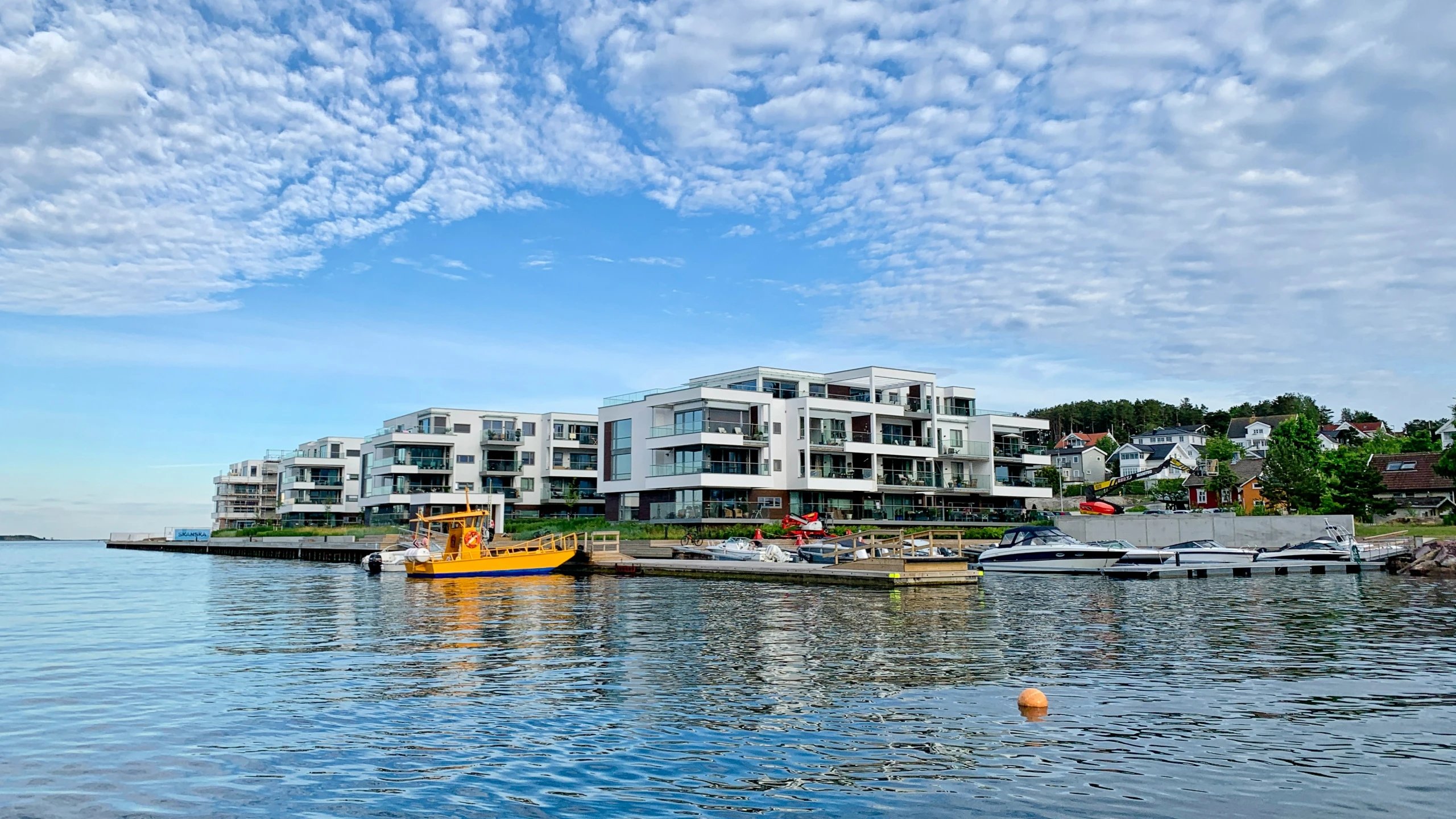 boats parked on the dock in front of several houses