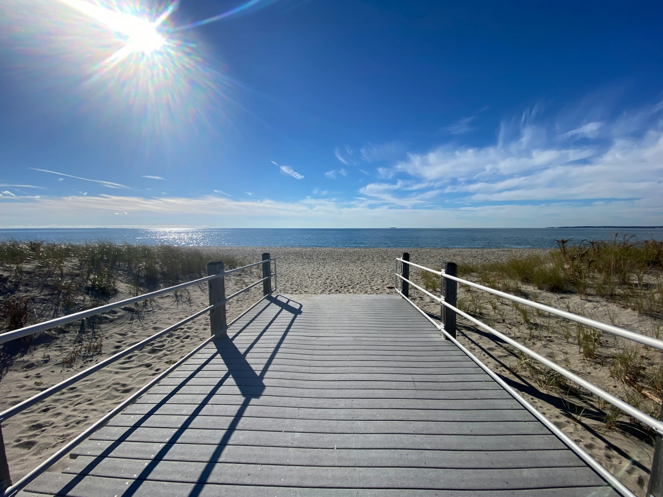 a boardwalk over looking an ocean at sunny day