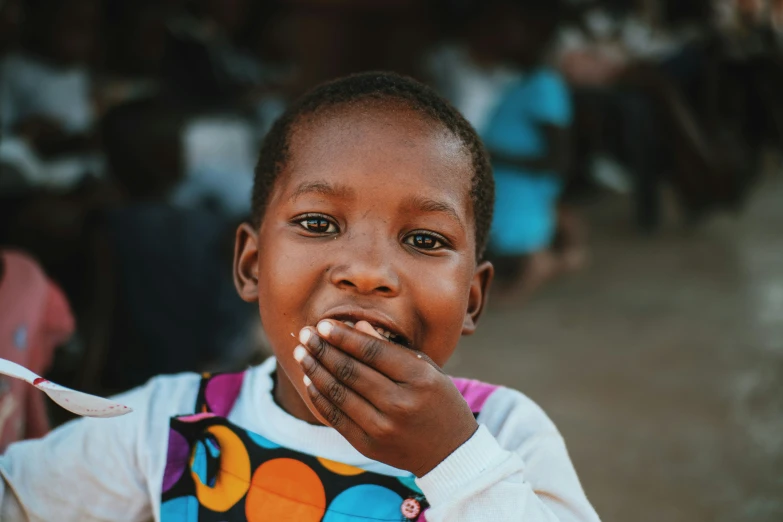 a child in africa with a fork and some spoons