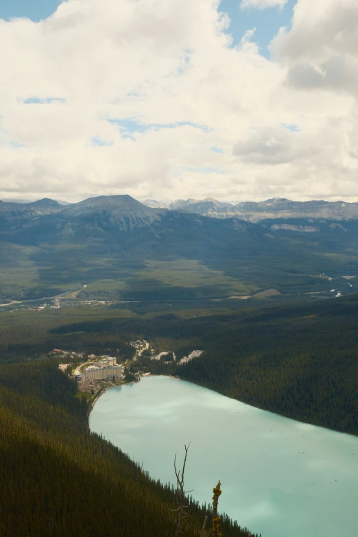 a lake near some mountains under a cloudy sky