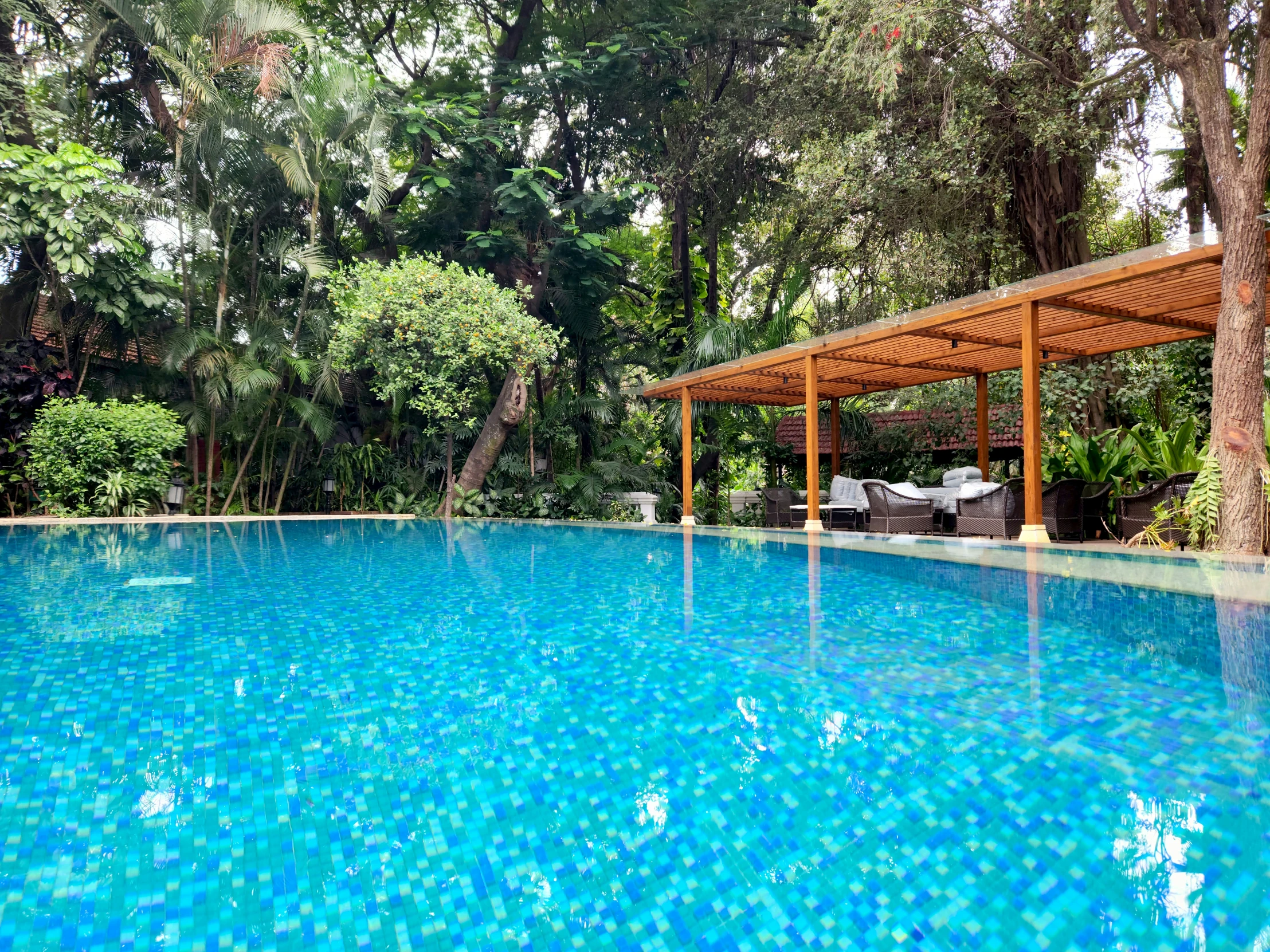 a pool that has trees and water next to it