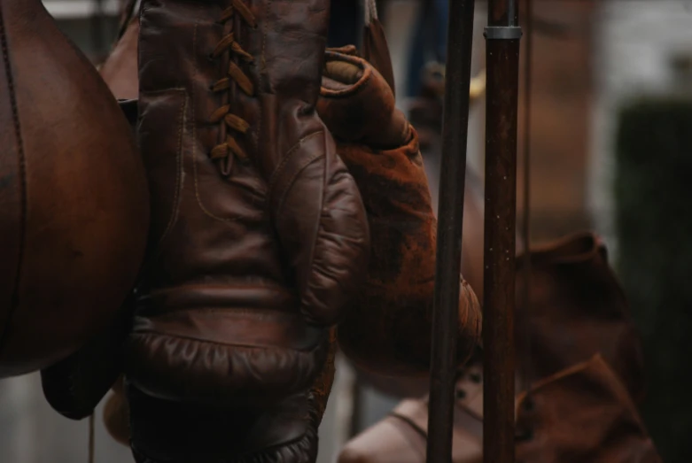 several pieces of brown leather hand gloves hanging from clothes rack