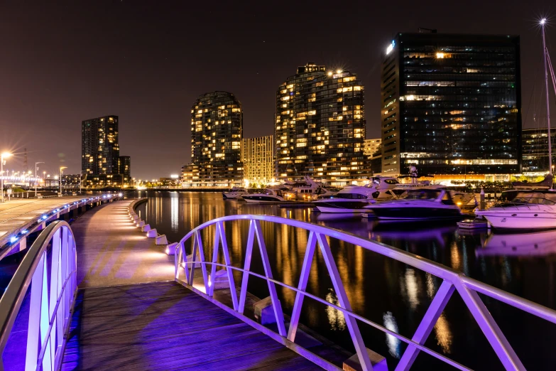 an illuminated pier with a view of a city skyline