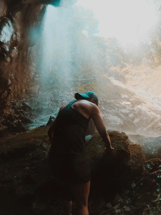 someone wearing a hat standing next to a stream