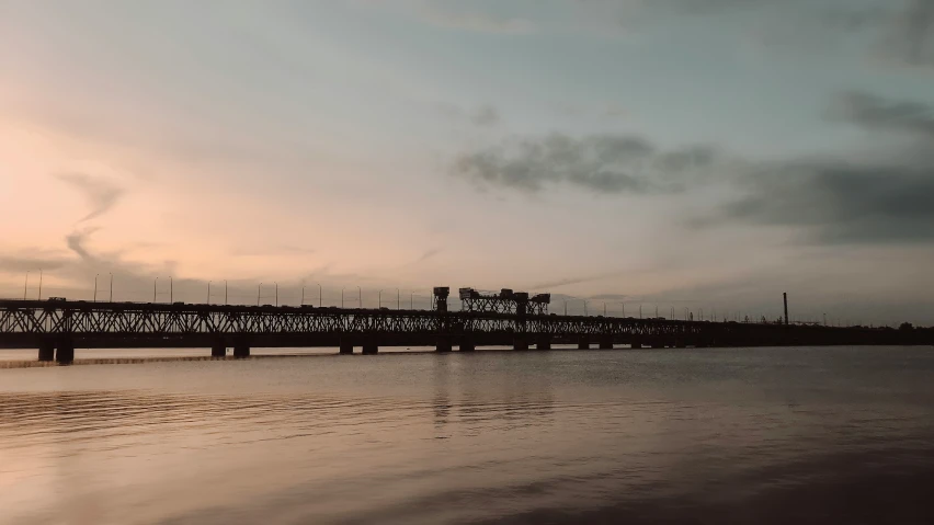 an empty bridge extends over a body of water