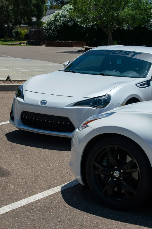 two white sports cars parked in a lot