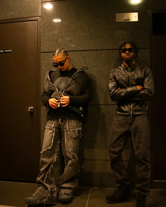 two men in front of an elevator dressed like them are standing outside