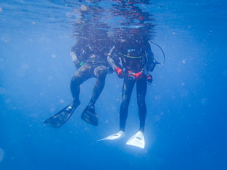 two scuba divers are going in the same direction