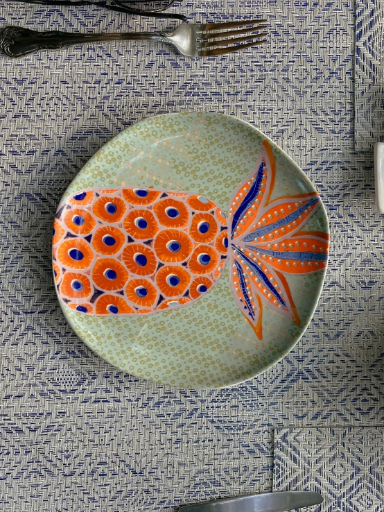 an orange broccoli design in the center of this plate