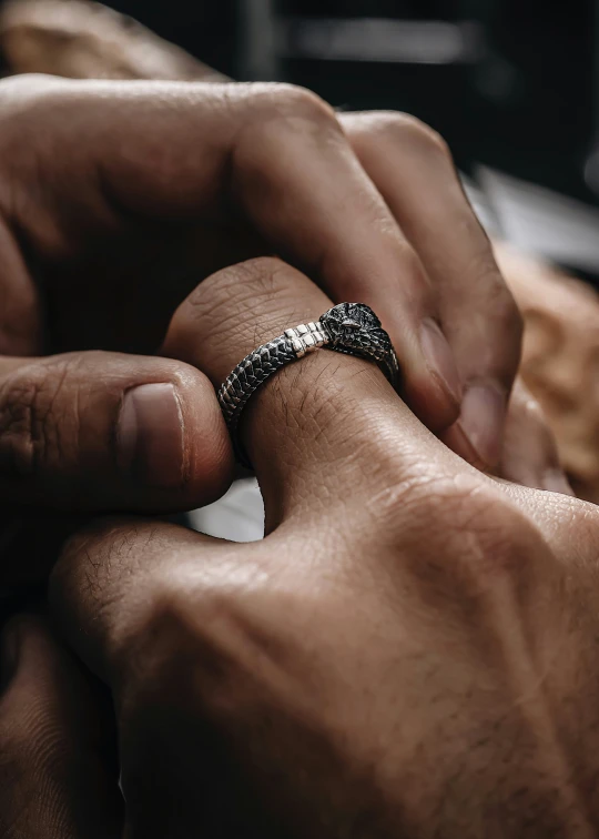 two people putting together wedding rings on each other