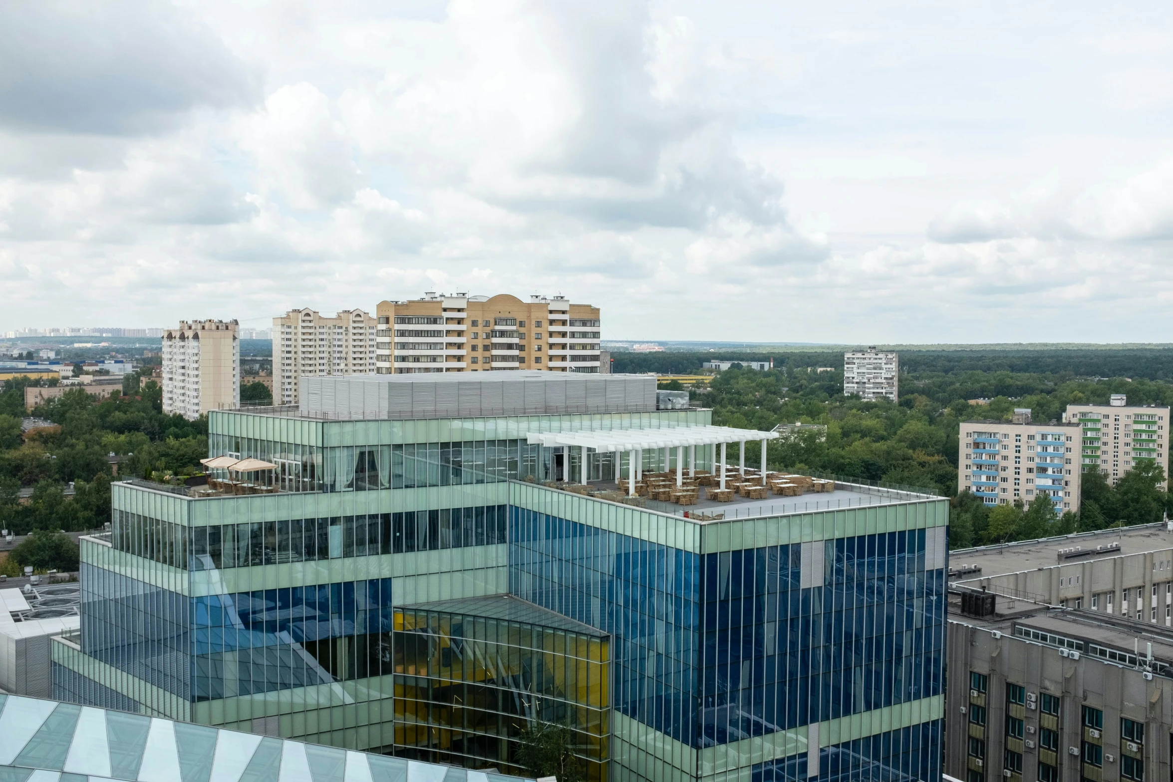 an aerial view of a glassy building in the background