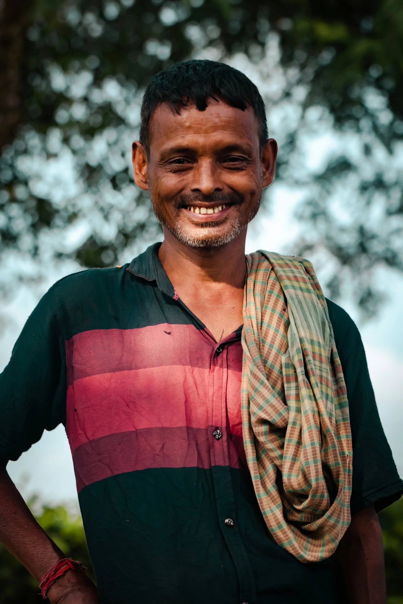 a man with an open smile wearing a striped shirt