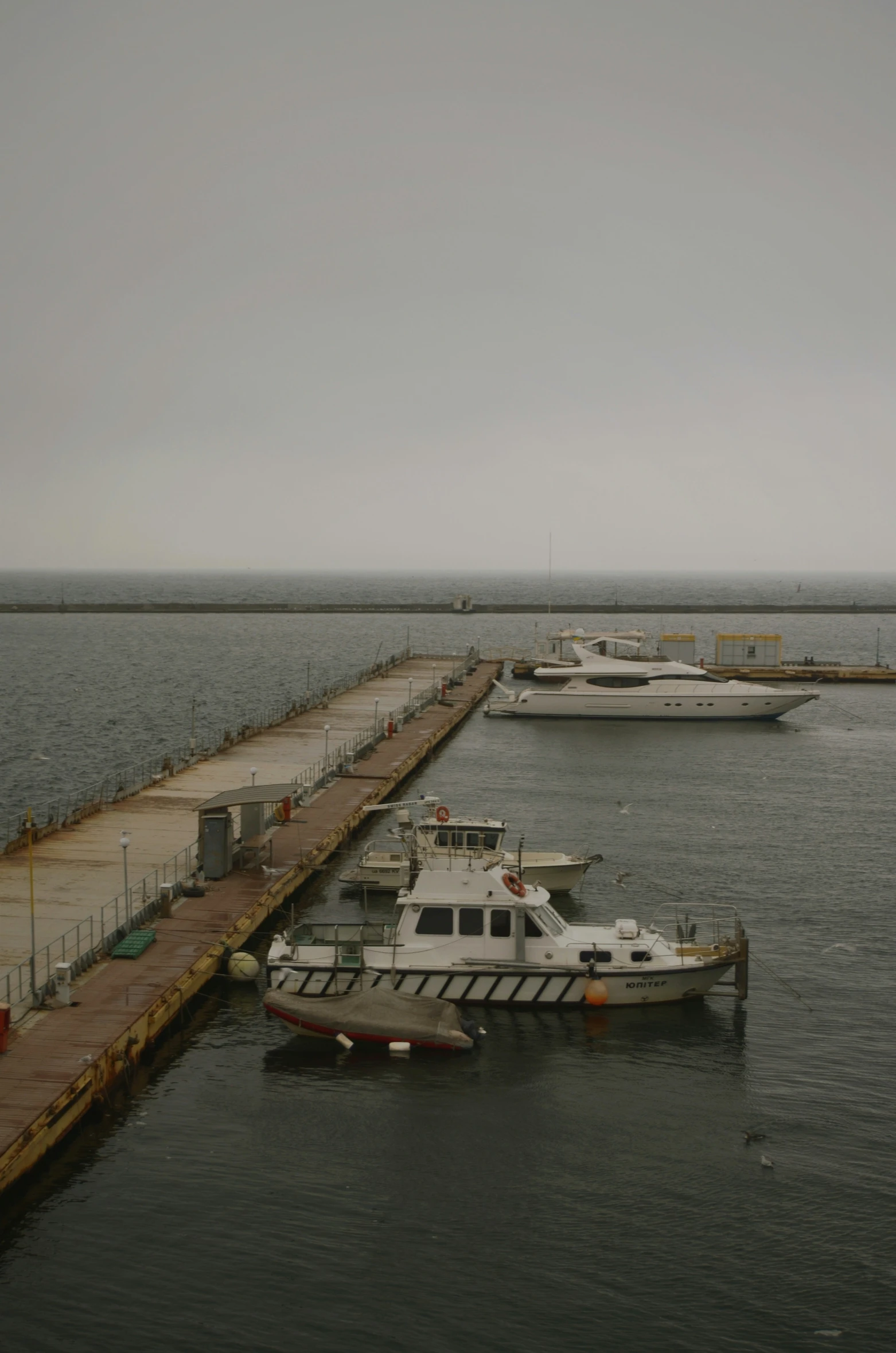 two white boats tied to the dock in a body of water