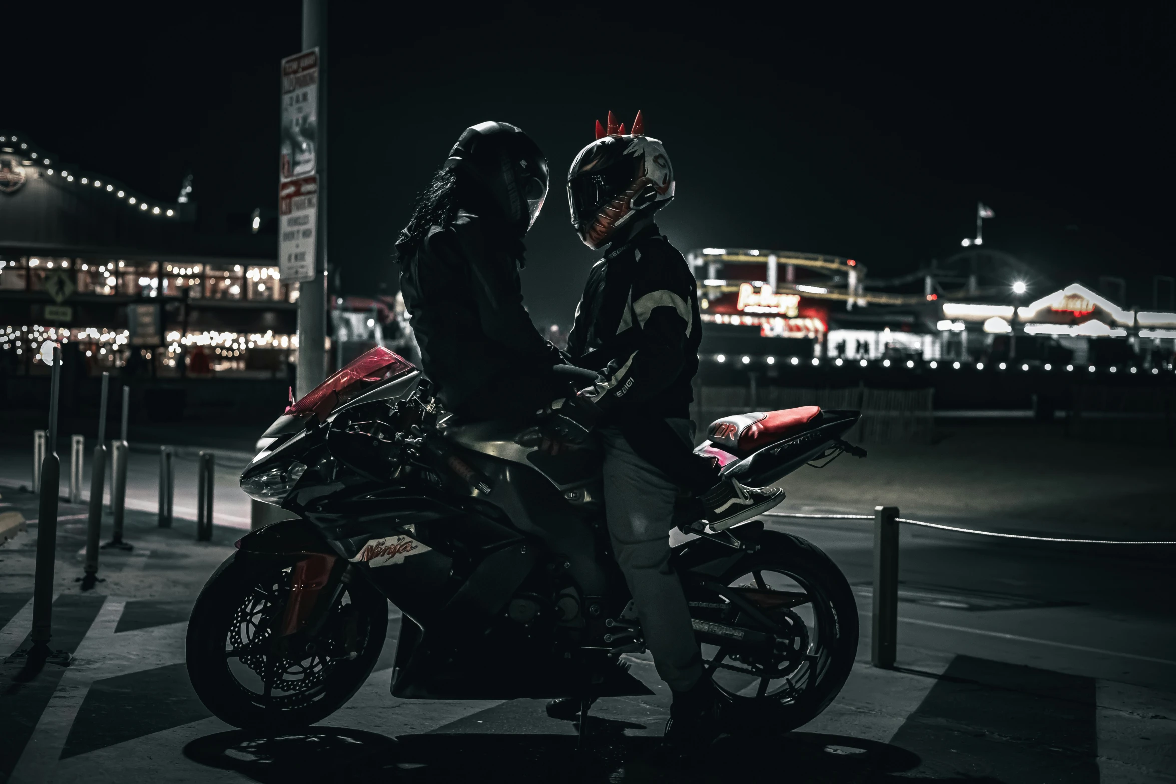 a pair of people sitting on motorcycles by the road