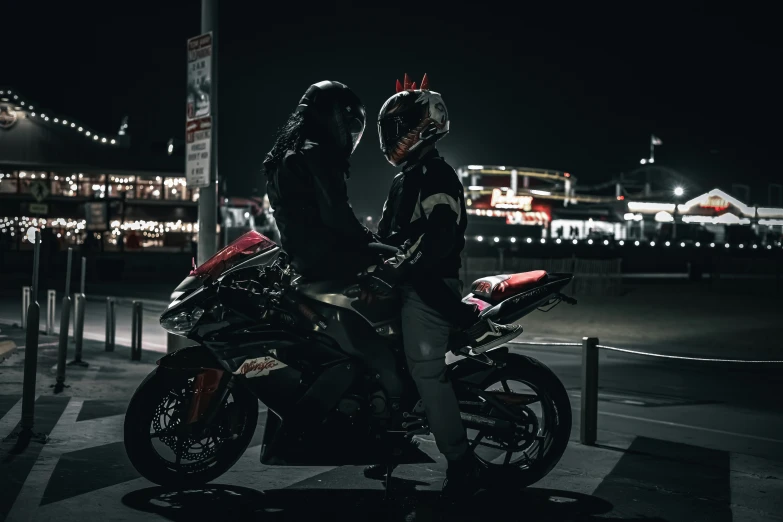 a pair of people sitting on motorcycles by the road