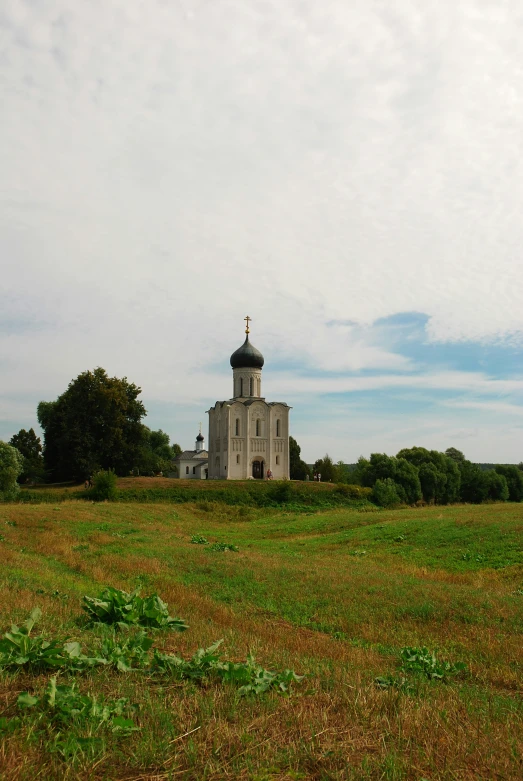 an old church is standing in a grassy field