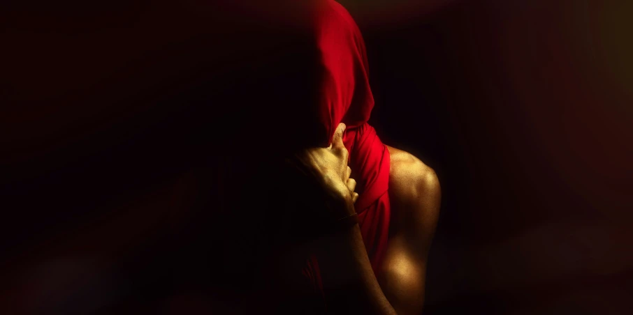 a woman is wearing red and holding her head with a red towel around it