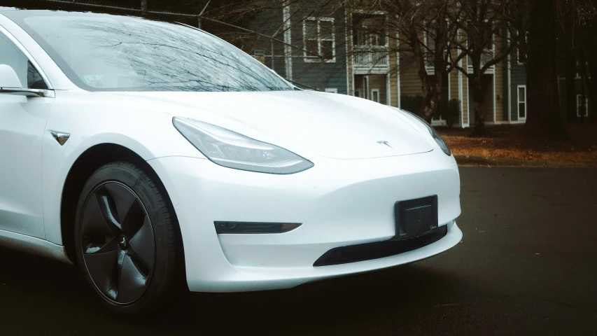 a white tesla electric car is parked on the street