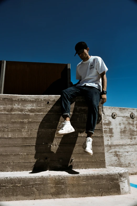 a young man sitting on some steps next to his skateboard