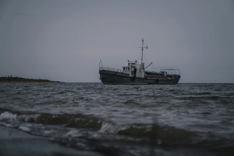 two boats anchored in the ocean on a cloudy day