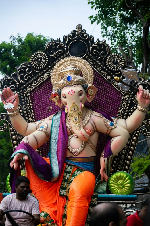 a large statue of an indian god sits atop a chair