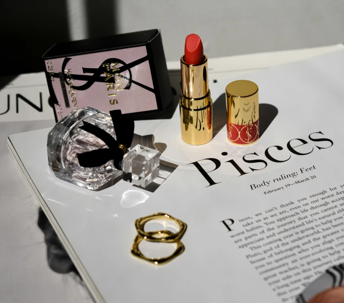 lipstick, ring and ring box on an open newspaper
