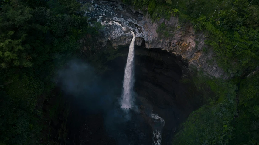 a waterfall with smoke pouring out the side