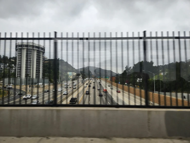 an out door view of a highway through a fence