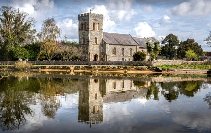 the reflection of a church and a lake in the water