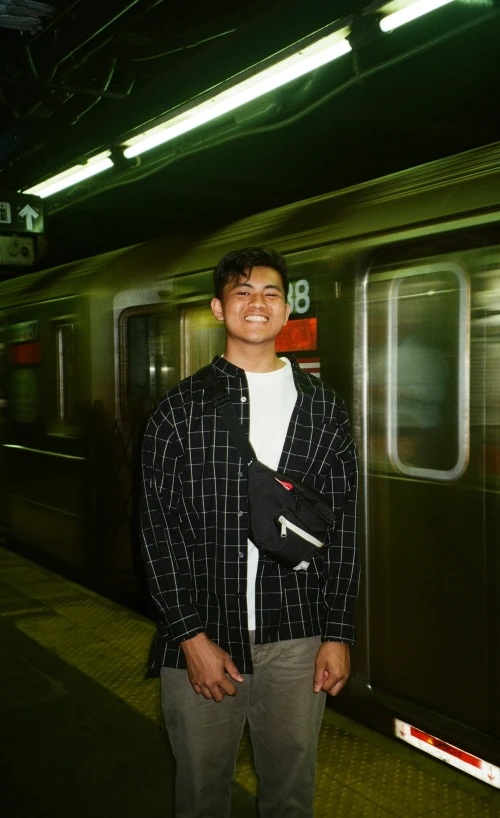 a young man stands near an open train door