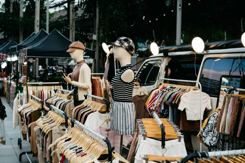 a few people are standing in front of some cloths