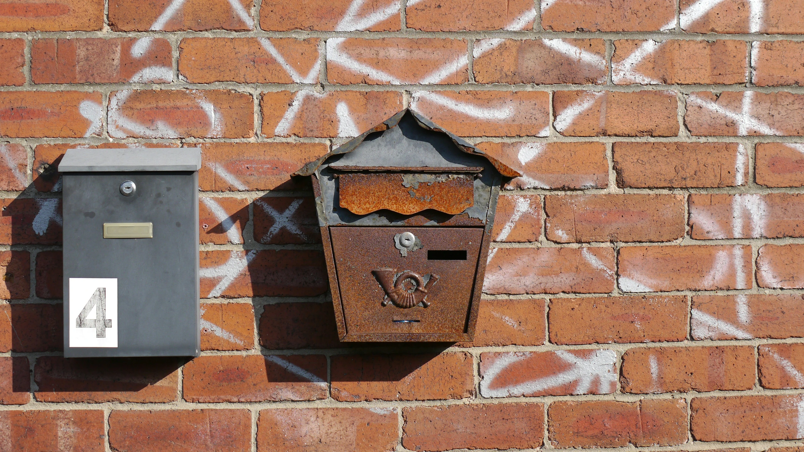 a mail box with face painting on brick wall