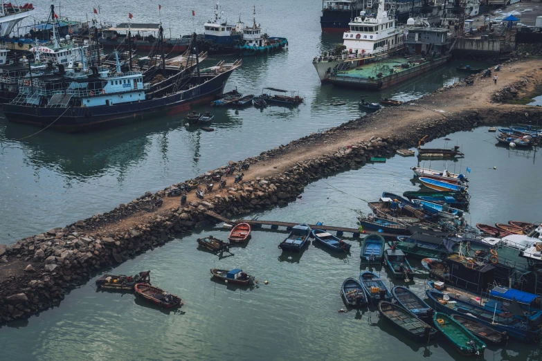 boats are docked in the water with large rocks around them