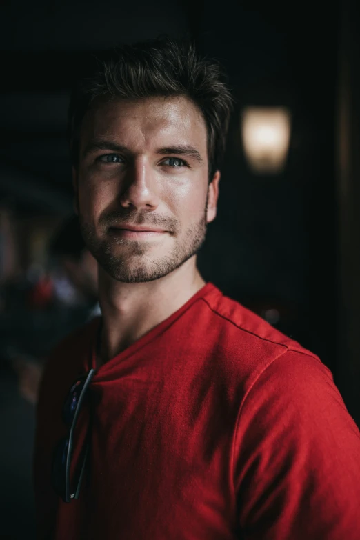 a man is smiling in his bright red shirt